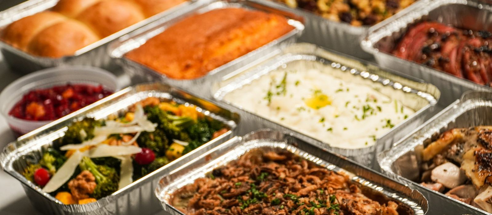 Foil catering trays filled with hot food, ready to be served