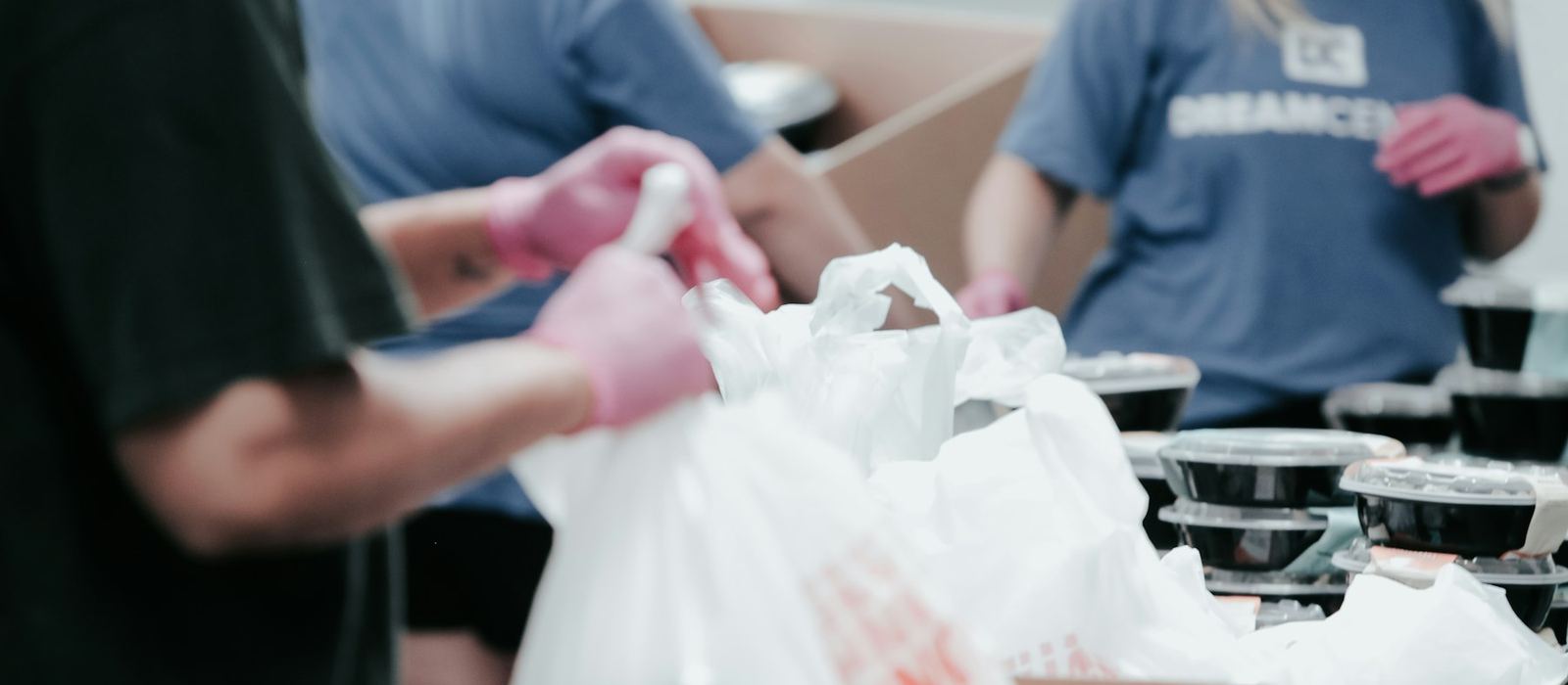 Volunteers packing food parcels into bags at a community distribution point